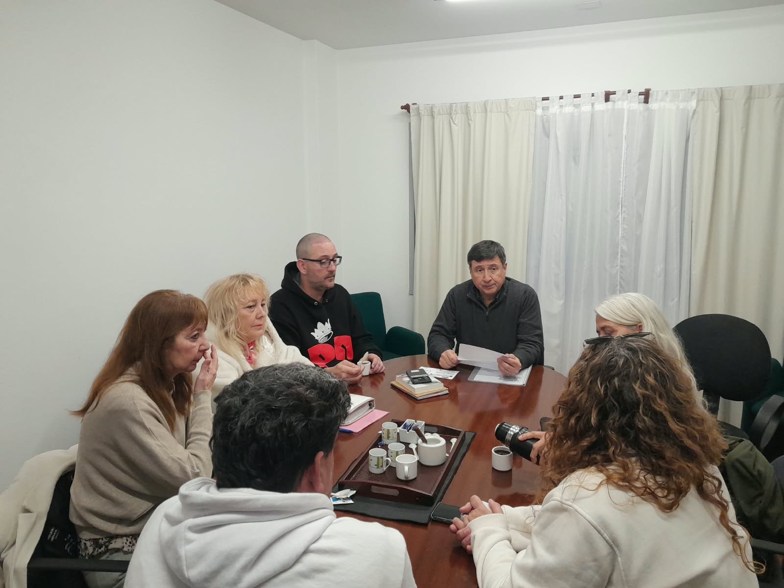 Integrantes de la organización trabajando alrededor de una mesa durante una reunión del congreso.